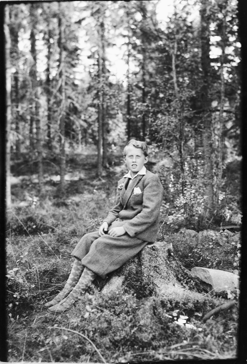 Håkon Prestkværn, Gutt i nikkers på en stubbe i skogen.