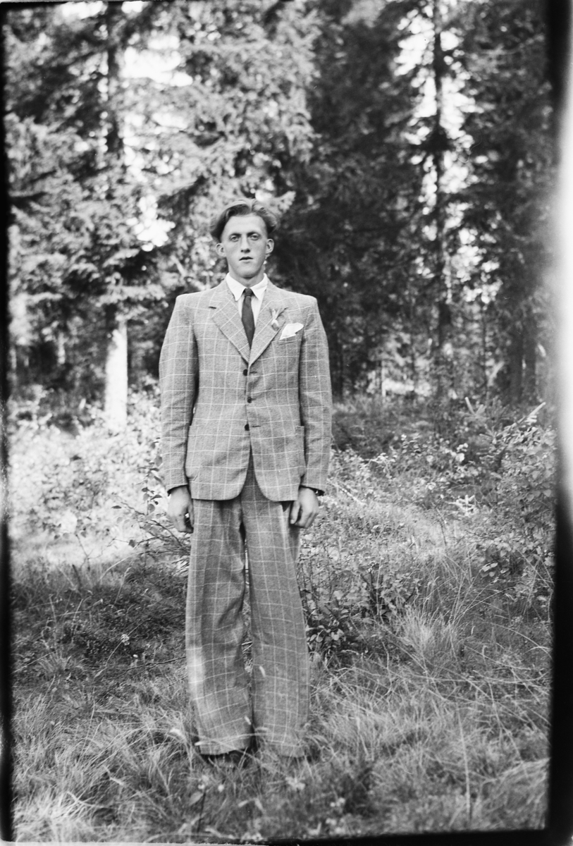 Håkon Prestkværn, Ukjent mann i dress i skogen.