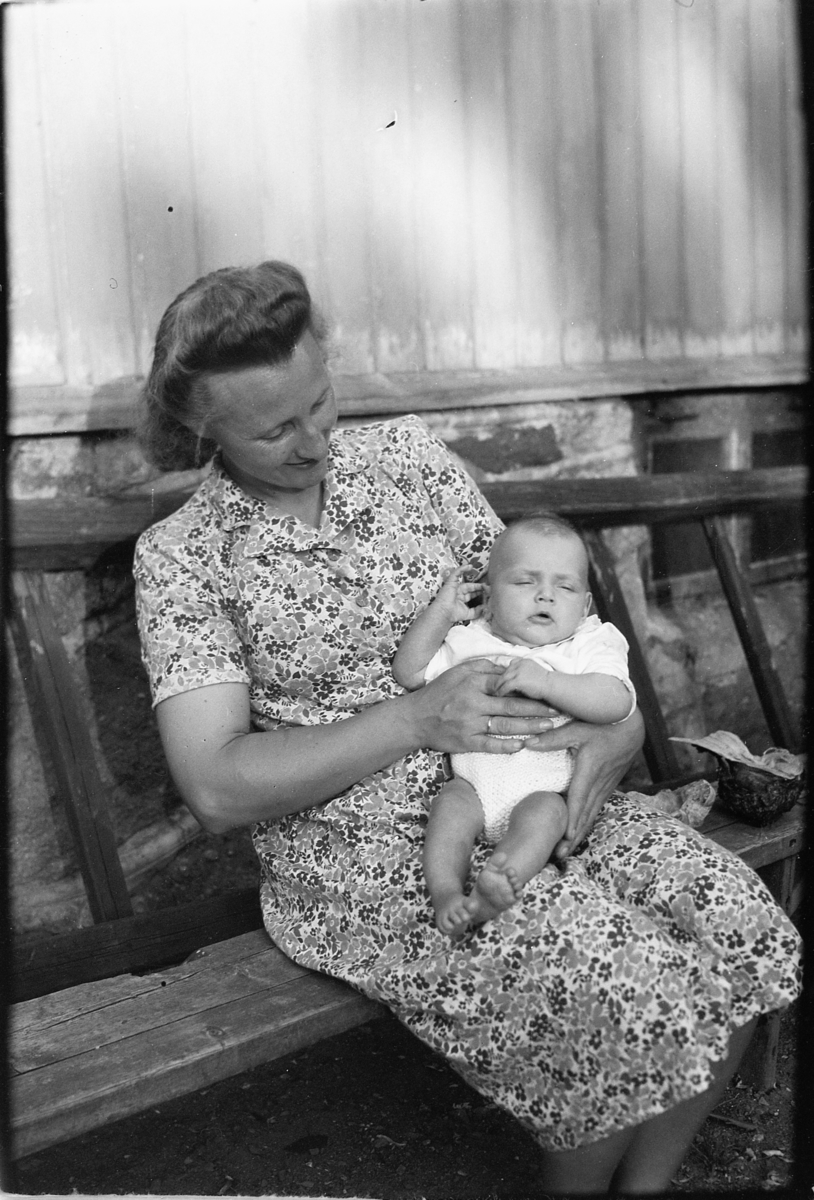 Håkon Prestkværn, Ukjent kvinne på en benk med en baby på fanget.