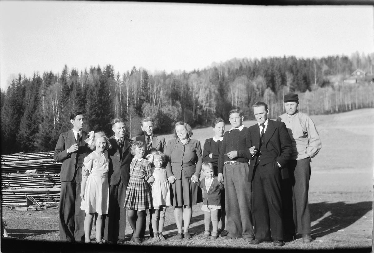 Håkon Prestkværn, Ukjent gruppe kvinner og menn står foran plankestabel og et jorde.