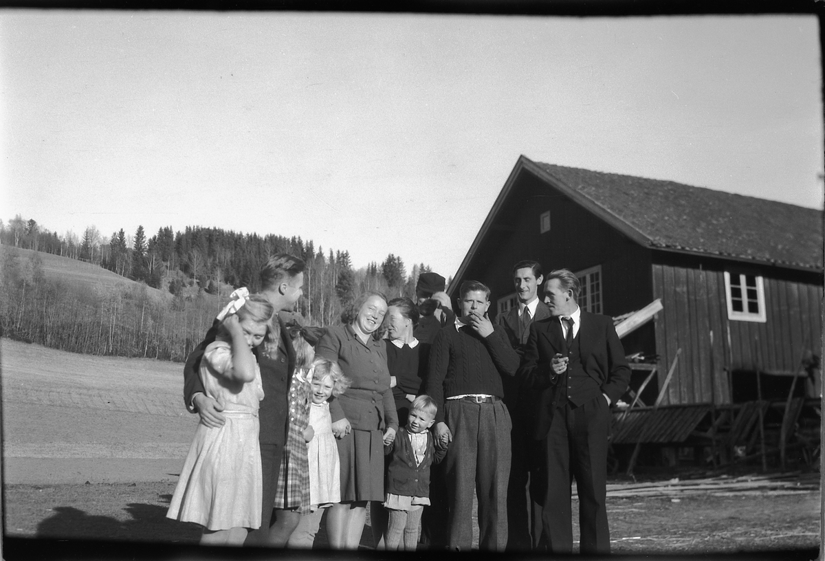 Håkon Prestkværn, Ukjent gruppe menn og kvinner foran et hus.