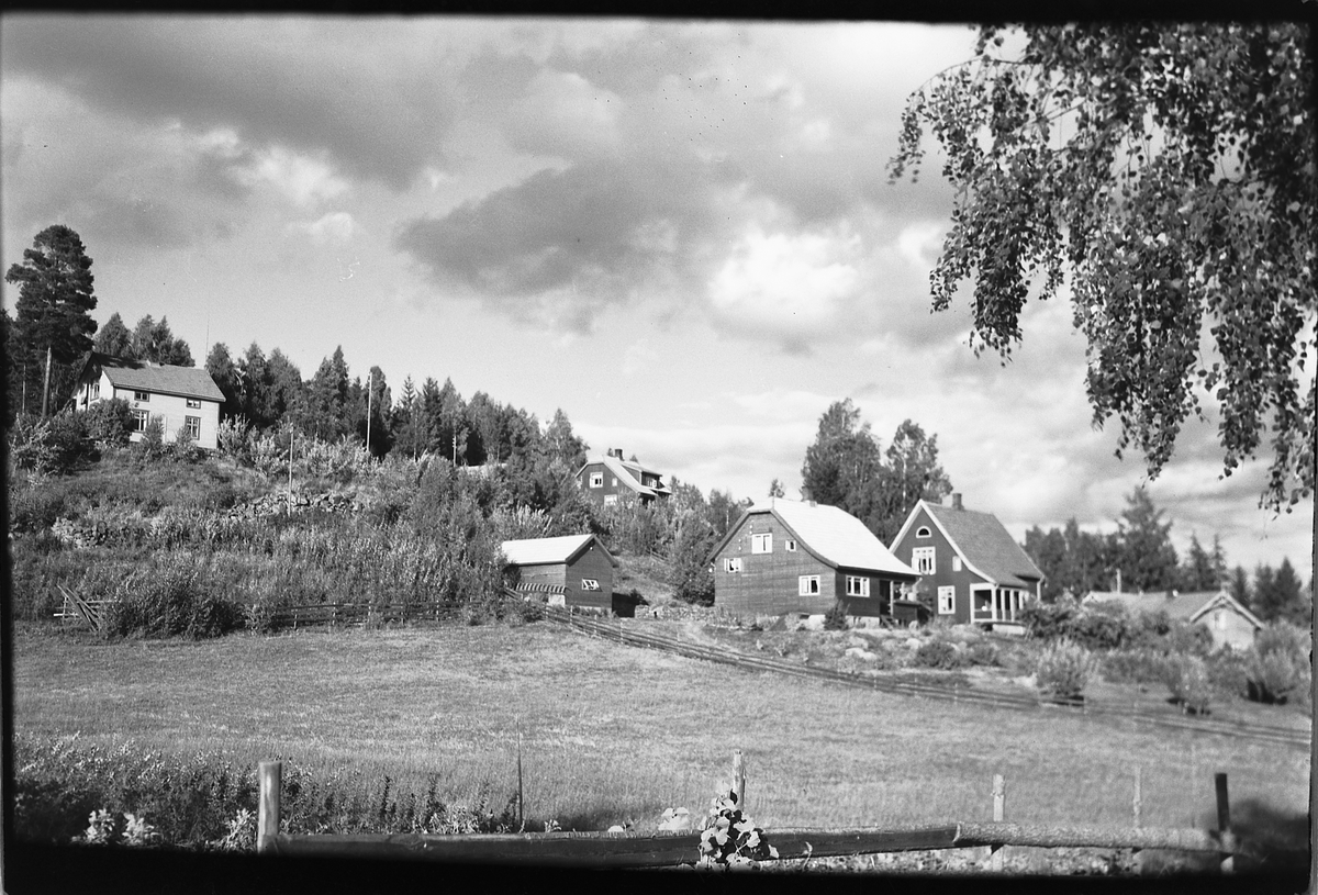 Håkon Prestkværn, Foto av en husklynge på hjørnet av Pinnerudvegen og Åsmarkvegen i Moelv. Jordet på bildet huser idag eldreboliger.