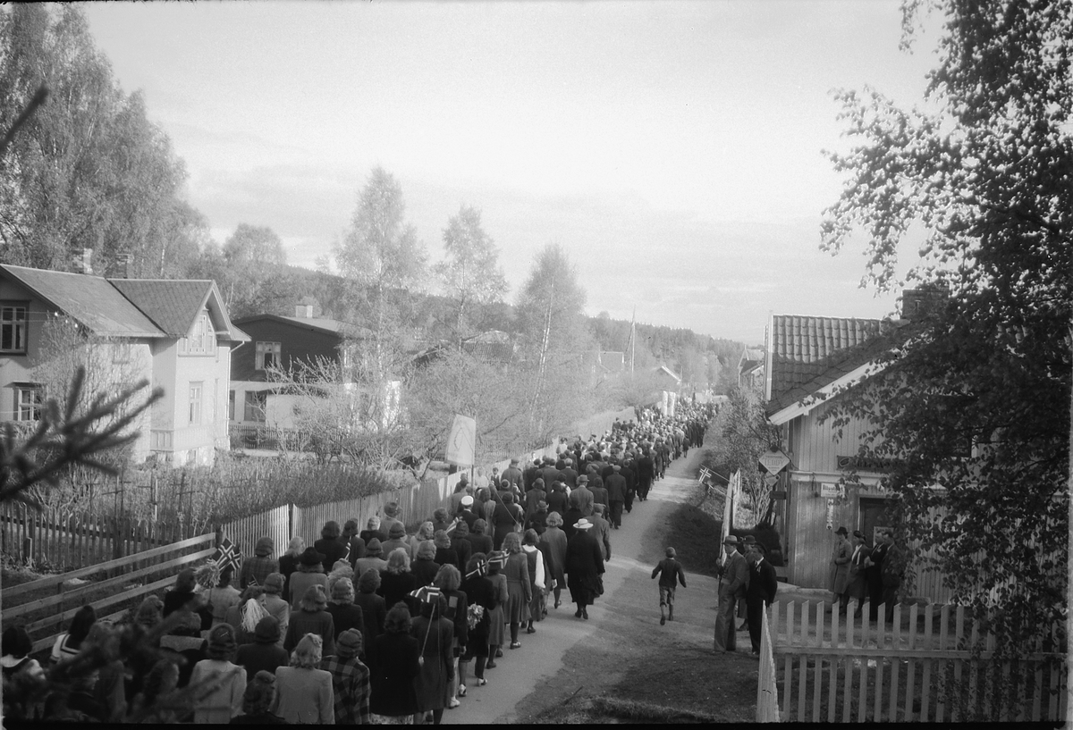 Håkon Prestkværn, Stor gruppe mennesker går i tog med faner og norske flagg.