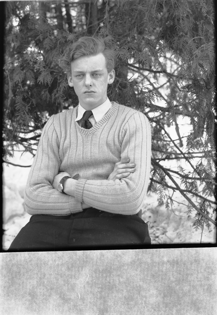 Håkon Prestkværn, Ukjent mann på en stol med et grantre i bakgrunnen.