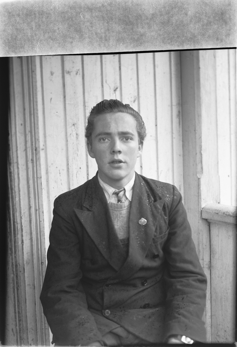 Håkon Prestkværn, Ukjent mann med dress og slips på trammen.