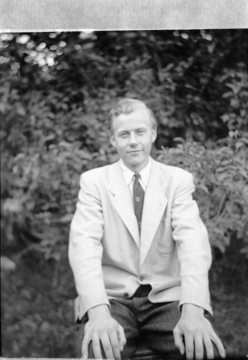 Håkon Prestkværn, Ukjent mann med dress i en hage.