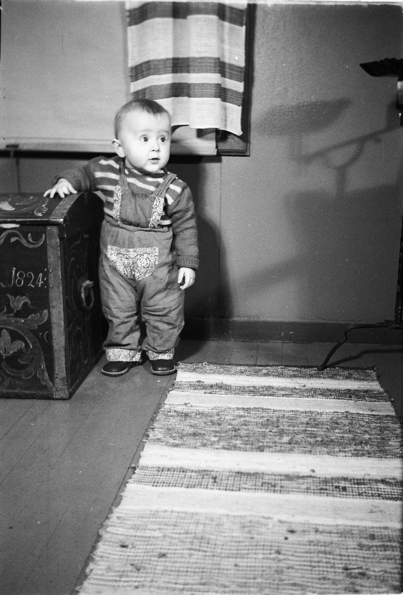 Håkon Prestkværn, Interiør, stue. Baby ved en sofa.