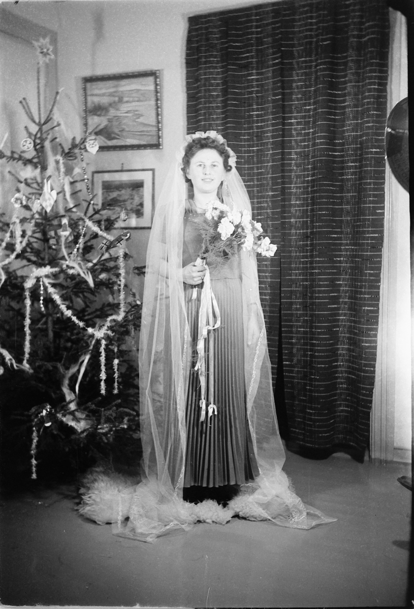 Håkon Prestkværn, Bryllup. Brud med blomster ved et juletre.