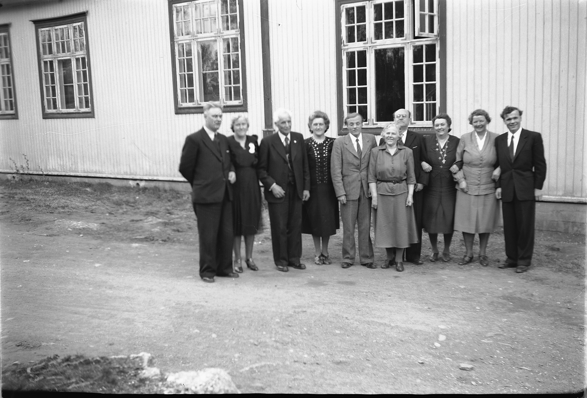 Håkon Prestkværn, Gruppe 10 eldre kvinner og menn foran Folkets Hus iMoelv. Erling Stordal står helt til høyre.