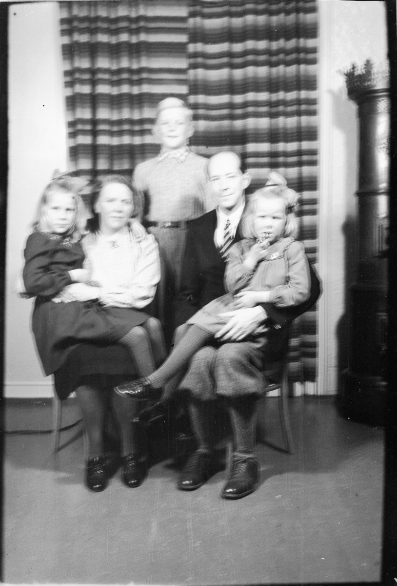 Håkon Prestkværn, Interiør, stue med ovn. Ukjent familie med tre barn.