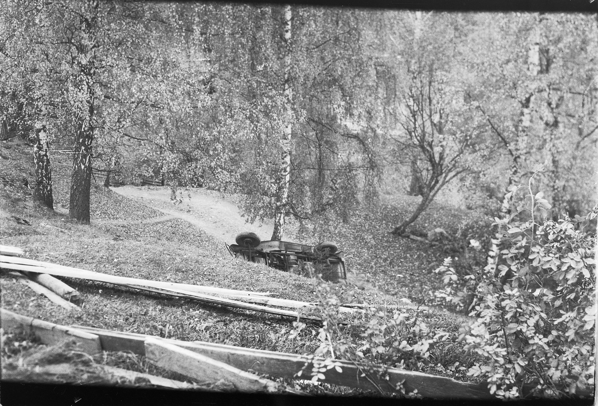 Håkon Prestkværn, Bilulykke. Varebil veltet i skråning. Moelv. John Strømman var uheldig og trillet ut over Lykkjebakken med sin fiskebil 1946-1947. Alt gikk imidlertid bra untatt med bilen en Opel P-4, D-3357, som nærmest ble vrak. Minda Kleiven står t. v. med sykkel.