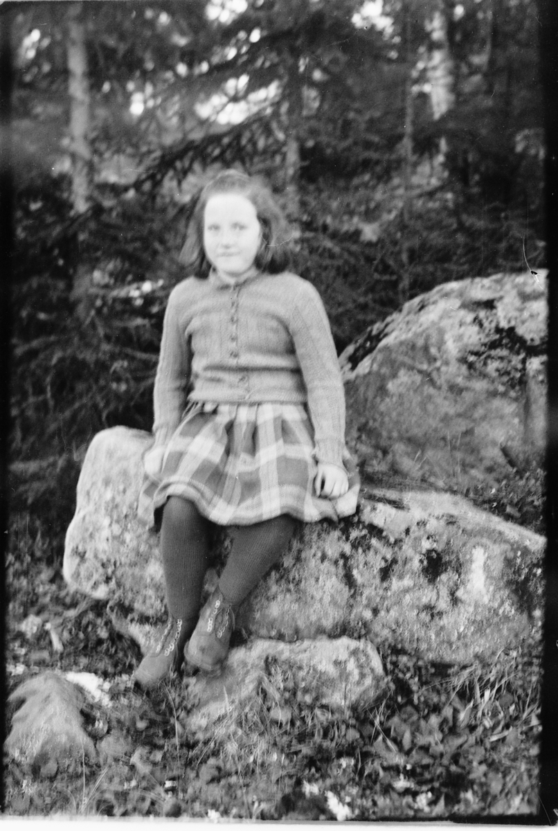 Håkon Prestkværn, Ukjent jente på en stein i skogen. Fotokonvolutt mrk. "Jarle Olsen okt. 1948"