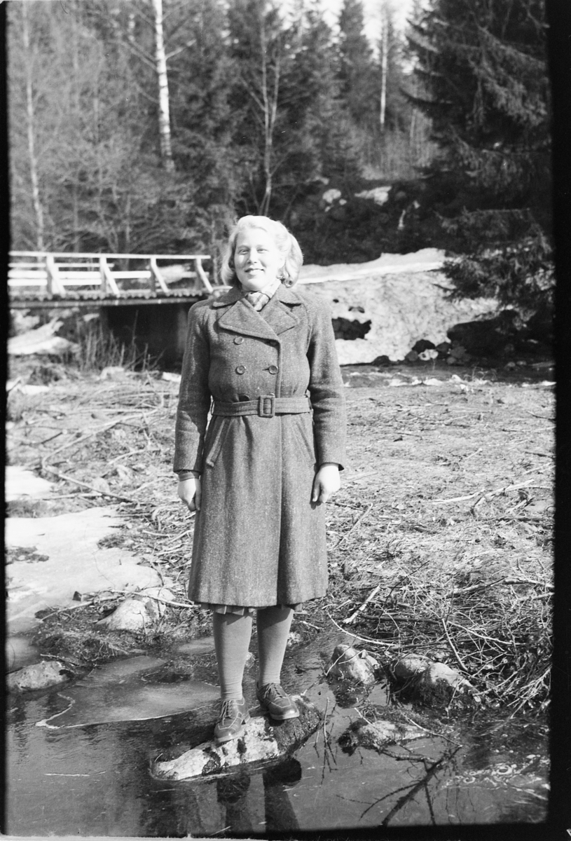Håkon Prestkværn, Ukjent kvinne står ved ei elv. Fotokonvolutt mrk. "Frknr. Hagen slutten april 1948"