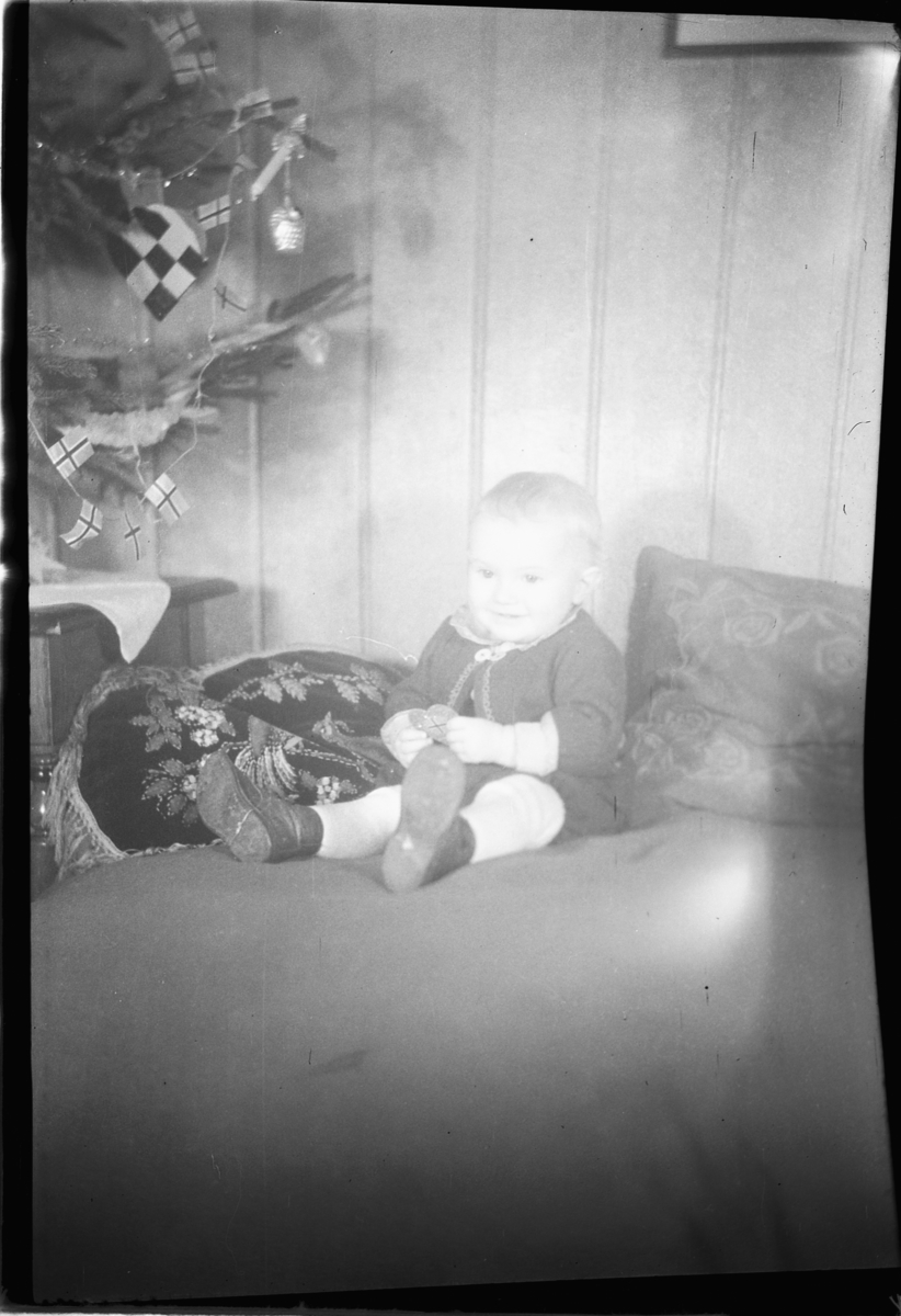 Håkon Prestkværn, Interiør, stue med juletre. Baby sitter i en sofa. "fotokonvolutt mrk. Aaseth julen 1948"