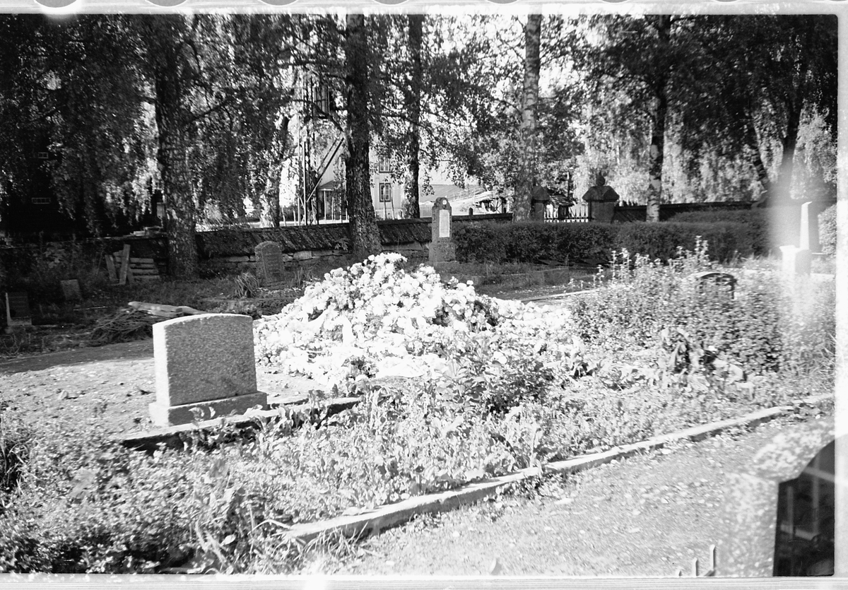 Håkon Prestkværn, En ny grav med blomsterkranser på en kirkegård.