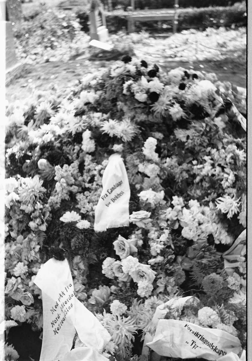 Håkon Prestkværn, En grav med blomsterkranser på en kirkegård.