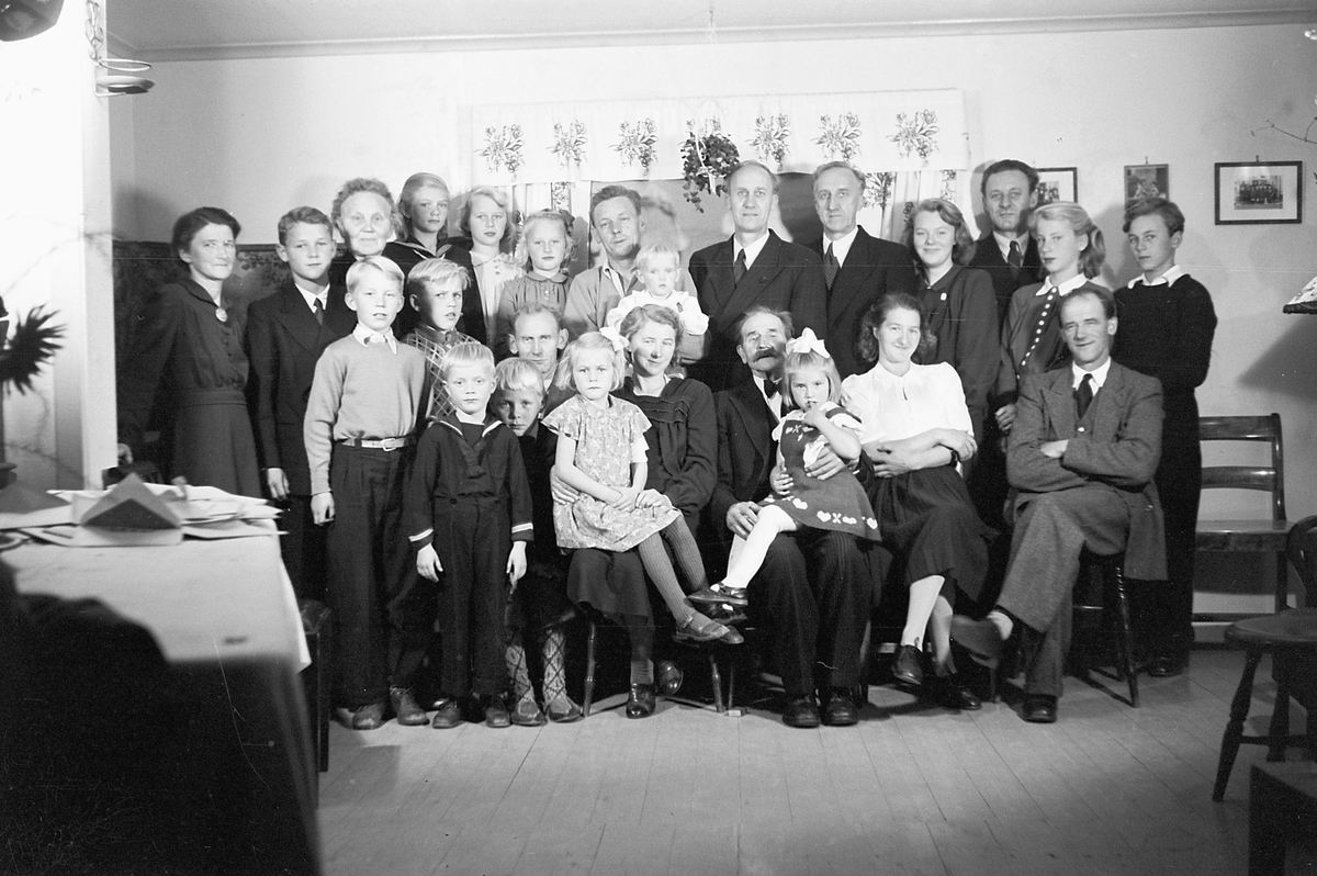 Håkon Prestkværn, Interiør, stue. Stor familiegruppe.