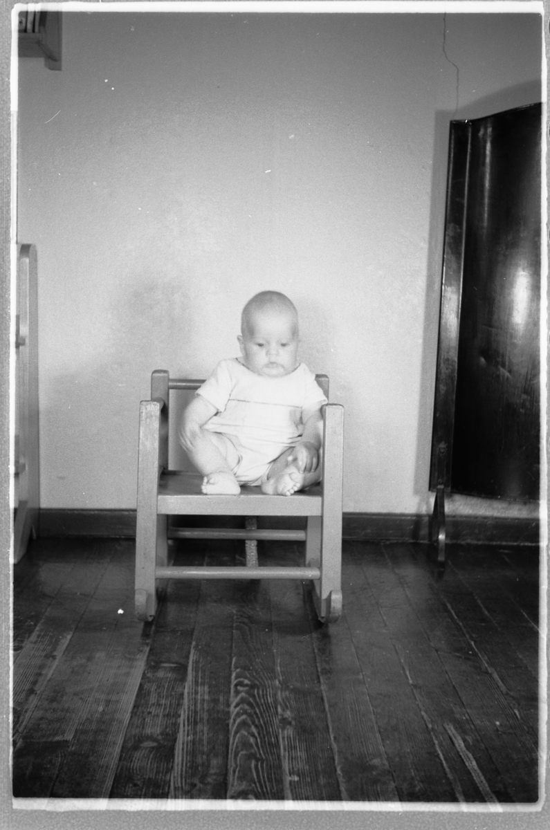 Håkon Prestkværn, En baby sitter i en stol.