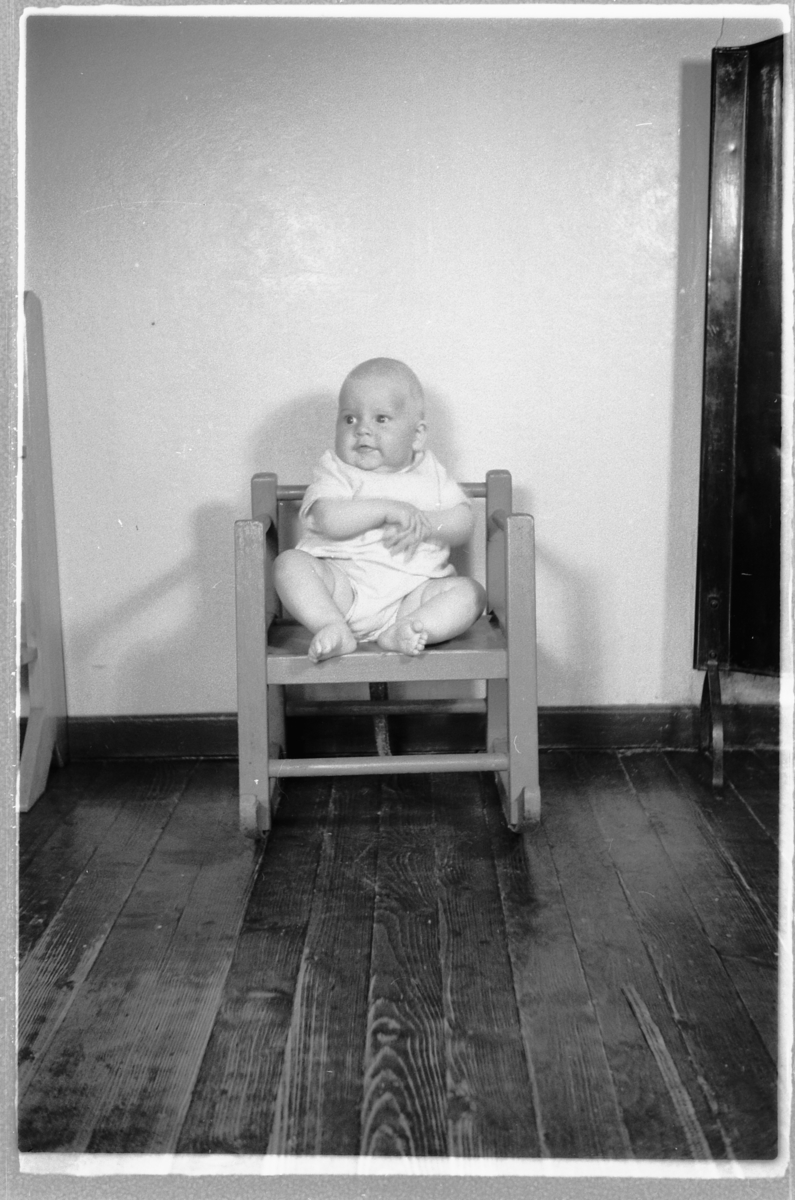 Håkon Prestkværn, En baby sitter i en stol.
