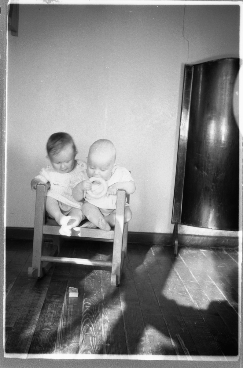 Håkon Prestkværn, Ei lita jente og en baby sitter i en stol.