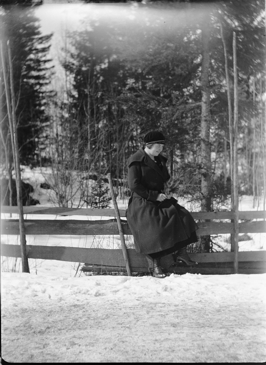 Ole M Martinsen, Ukjent kvinne sitter på en skigard med granbar i hendene.