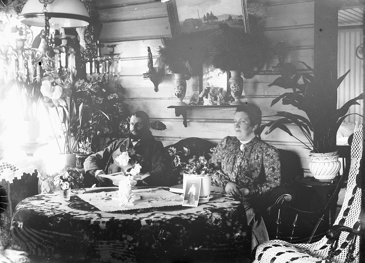 Ragnvald Andersen, Interiør, stue. Ukjent mann og kvinne i en sofa.