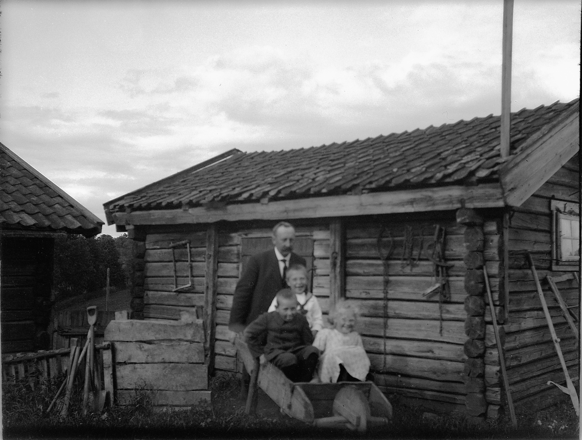 Ragnvald Andersen, Nyborg, plass under Børstad i Hamar. Ukjent mann triller tre barn i en trillebår.