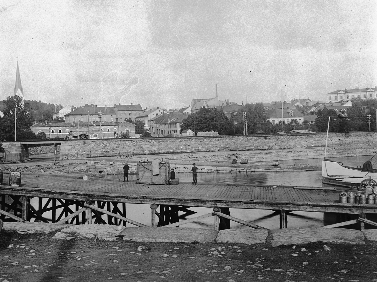 Hans Emil Erichsen, Hamar brygge med dyrekasser, sprittønner og melkespann. Basarbygningen i bakgrunn.