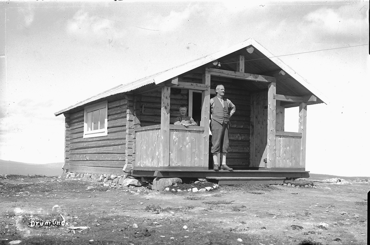 Oscar Løberg, Ukjent gutt og mann på verandaen til ei hytte på Brumundkampen.