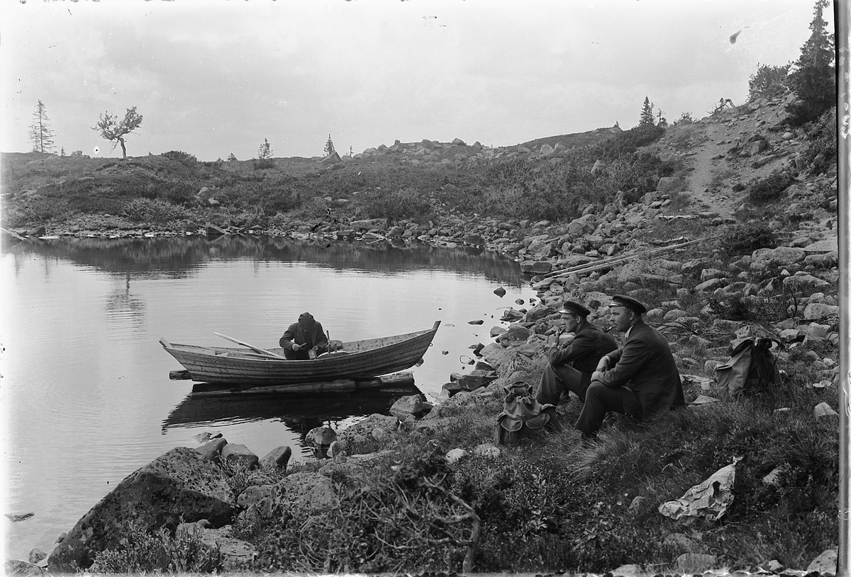 Simen Baardseth, Per Baakind, Johannes Tranget og H. J. Røed på fisketur. Robåt, ryggsekker, pipe.