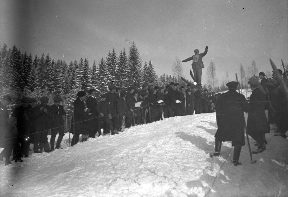Simen Baardseth, SKIHOPPBAKKE. Mann i svevet, publikum på sidene. Enten Ekkerdal eller Flatfossbakken.
