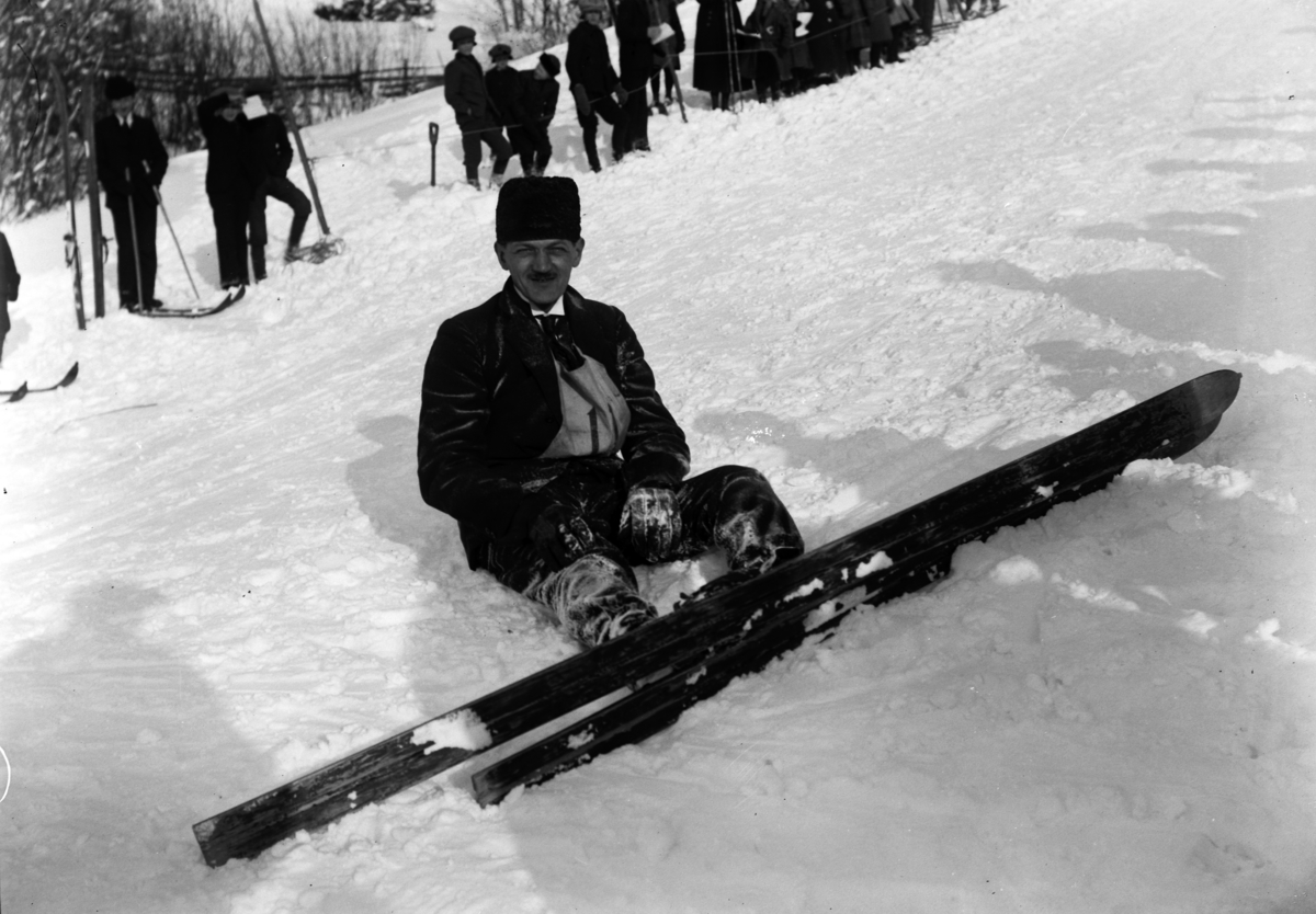 Simen Baardseth, SKIHOPPBAKKE. Skihopper i snøen. Publikum i bakgrunnen.