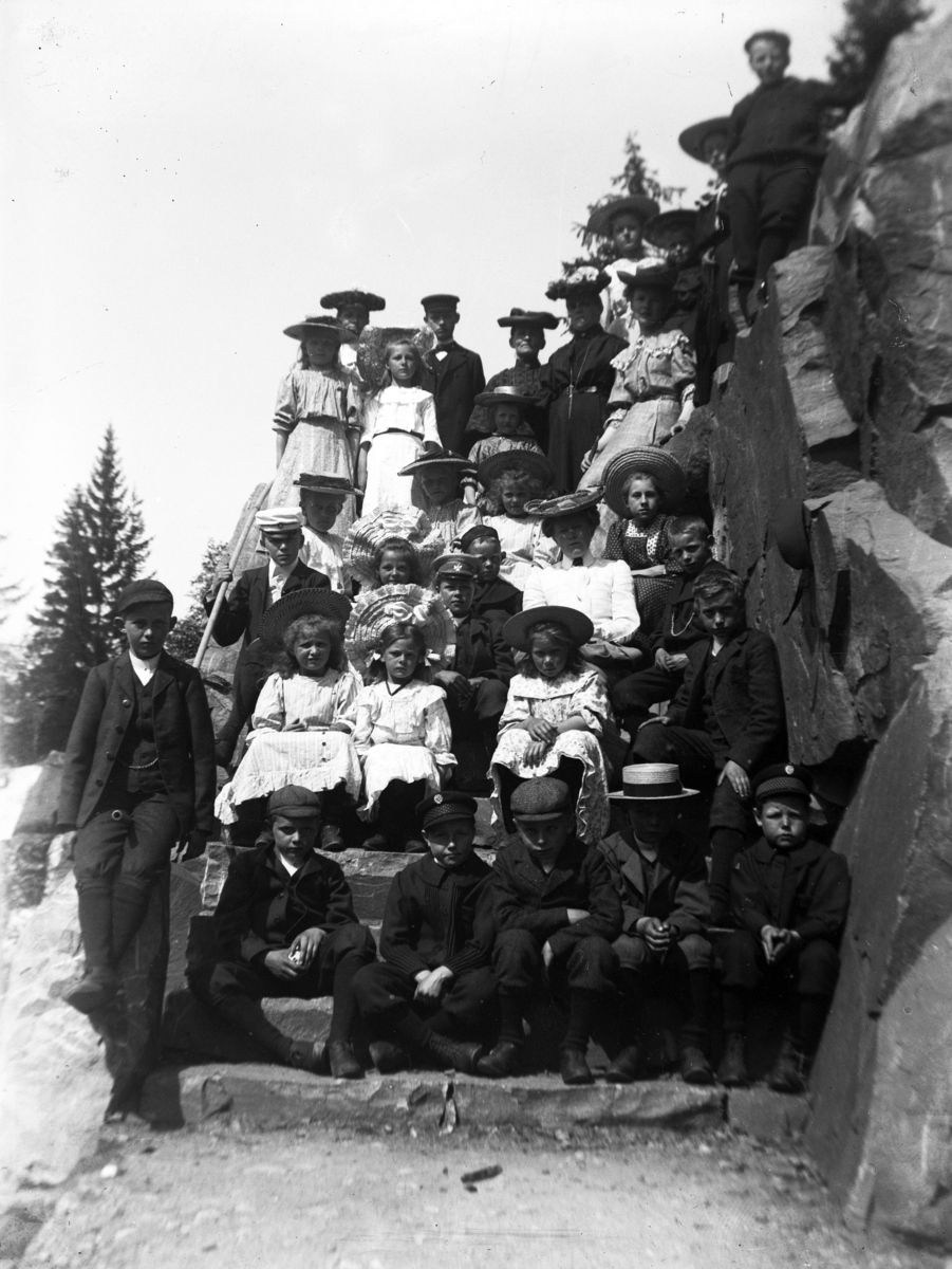 Kristian Heramb, Stor gruppe barn. Eldre kvinner i bakgrunnen.