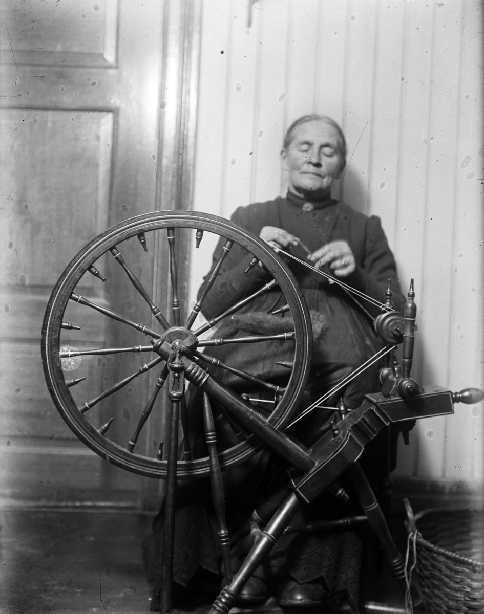 Kristian Heramb, Eldre kvinne spinner garn med rokk, spinnerokk.
