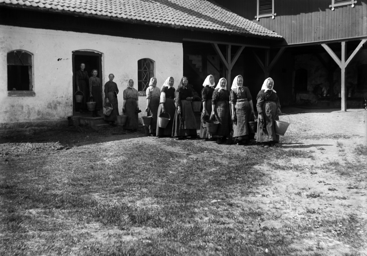 Martin Finborud, Grefsheim, Nes, Hedmark. 11 budeier på vei ut av fjøset med bøtter etter vask av fjøset.