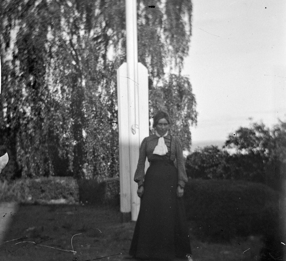 Jacob Tollesen Hoel, Anna Benjamine Hoel (født 30/3-1872) ved flaggstangen på Hovinsholm gård, Helgøya i Ringsaker. Foto Jacob Hoel.