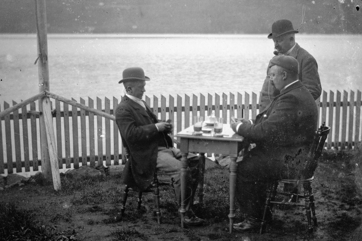 Hans Emil Erichsen, Tre ukjente menn spiller kort. Glass med drikke på bordet.