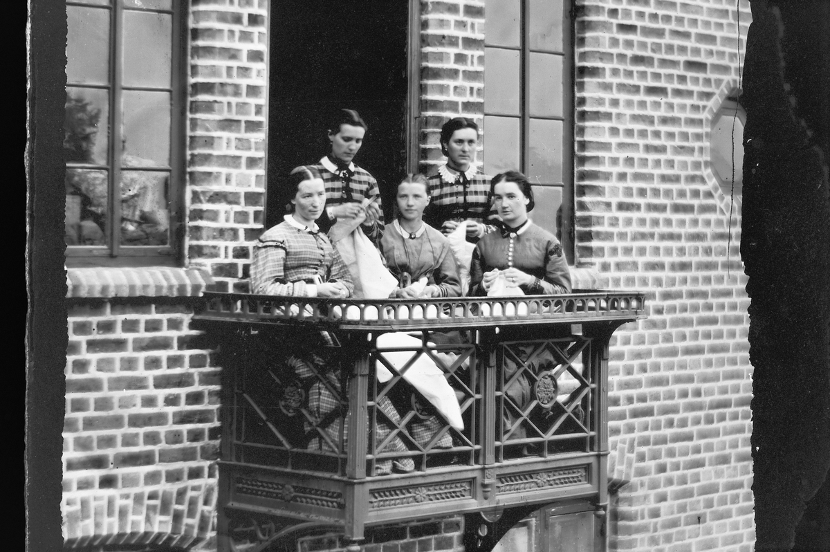 Hans Emil Erichsen, 5 ukjente kvinner på balkong med håndarbeid. Hos brukseier Edvard Erichsen, Schultzehaugen, Kristiania.