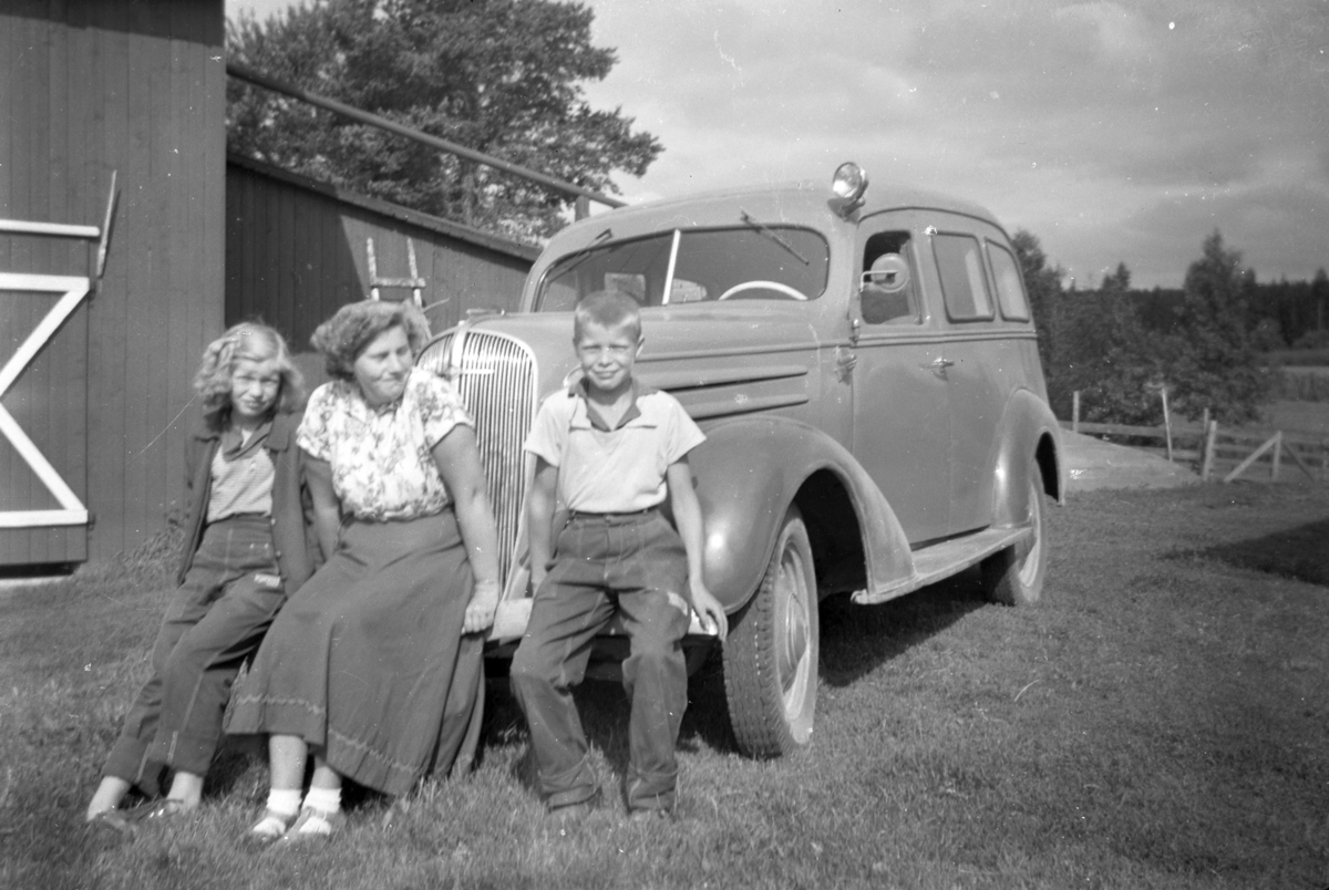 Håkon Prestkværn, gruppe 3 ukjente foran personbil, Chevrolet 1936.