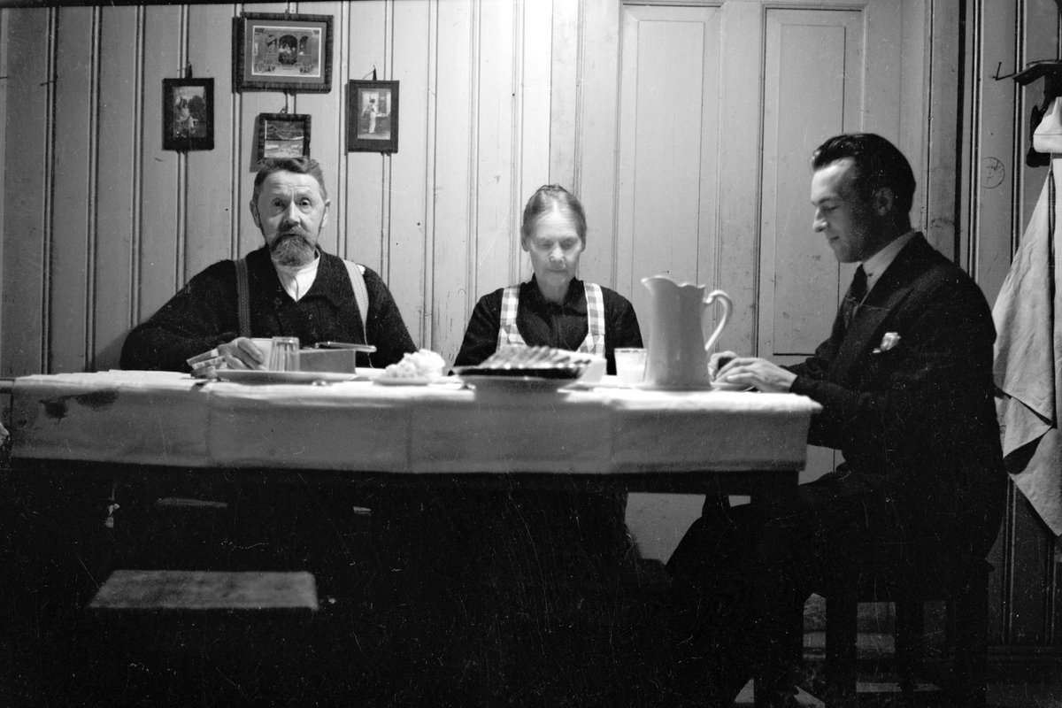 Håkon Prestkværn, Tre personer samlet rundt bord, måltid, frokost i Løkkekværn, Moelv. F. v Kristian Prestkværn, Gunda Prestkværn og ukjent.