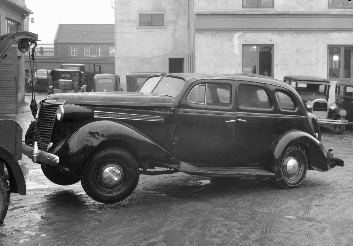 Normann Fotoatelier, Oplandske Auto. Kollisjonskadet bil, D-6033. Hamar. Nash Ambassador Six 1938, nærmest bak til høyre en Ford A 1928-29.