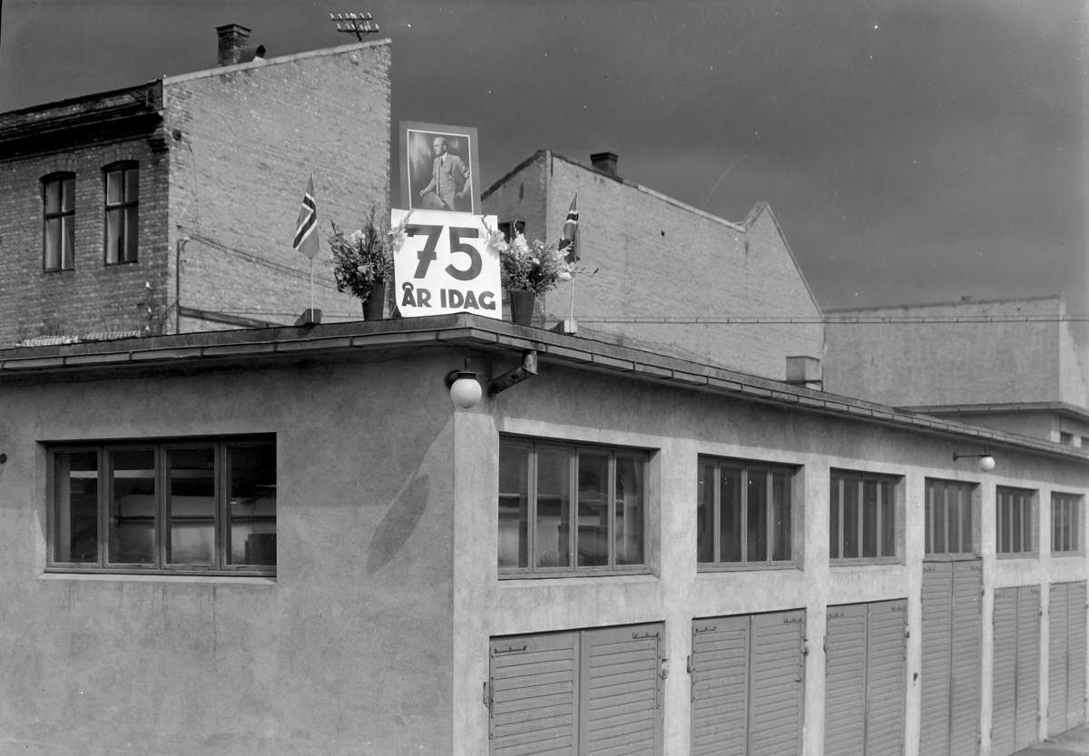 Normann Fotoatelier, Oplandske Auto. 75 års i dag. Jubileumsmarkering på taket. Hamar.