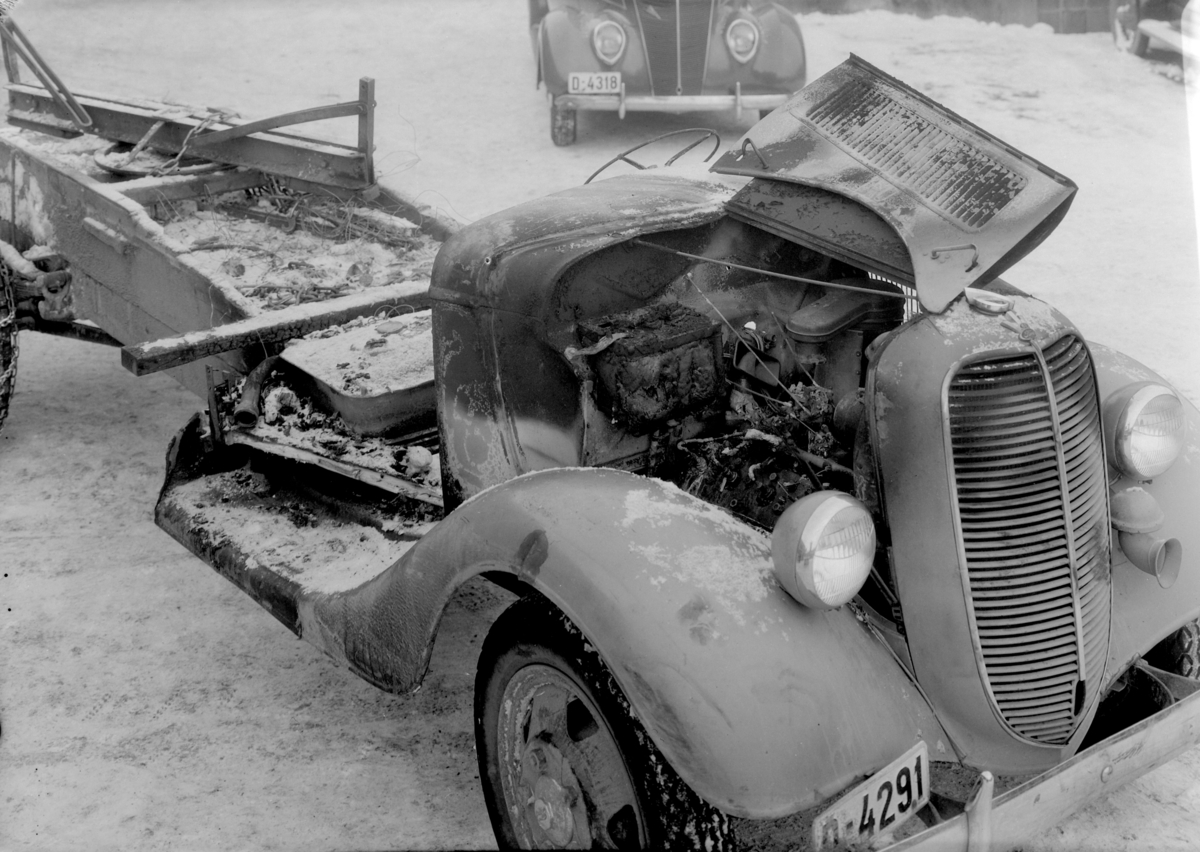 Normann Fotoatelier, Oplandske Auto, Hamar. Kolisjonskadet bil. D-4291. Lastebilen D-4291 er en Ford V8. Bilen i bakgrunnen ser ut til å ha reg. nr. D-4318 og er en Ford V8 1937 personbil. I Hvem eier bilen 1948 står D-4291 på en helt annen bil, men D-4318 er på en Ford personbil, årgang ikke oppgitt, som tilh. Arild L…