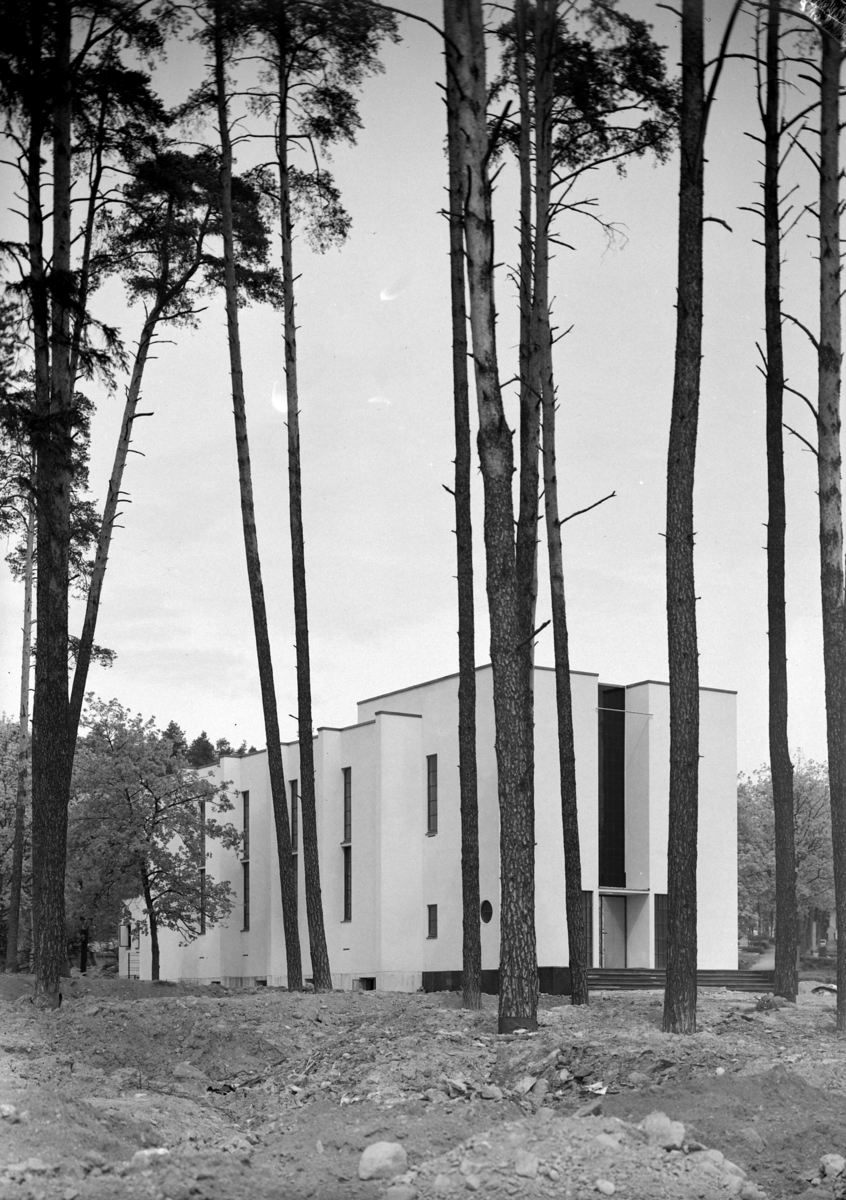 Normann Fotoatelier, Hamar krematorium. Hamar. Arkitekt Prag. Eksteriør før replanting og plen. Arkitekt Rolf Prag født på Hamar 1899, studerte ved høgskolen i Trondheim, var 5 år i Amerika, arbeidet hos Ole Øvergaard i Oslo til 1934 og flyttet deretter hjem til Hamar. Prag har bla. tegnet krematoriet fra 1937 og av st…