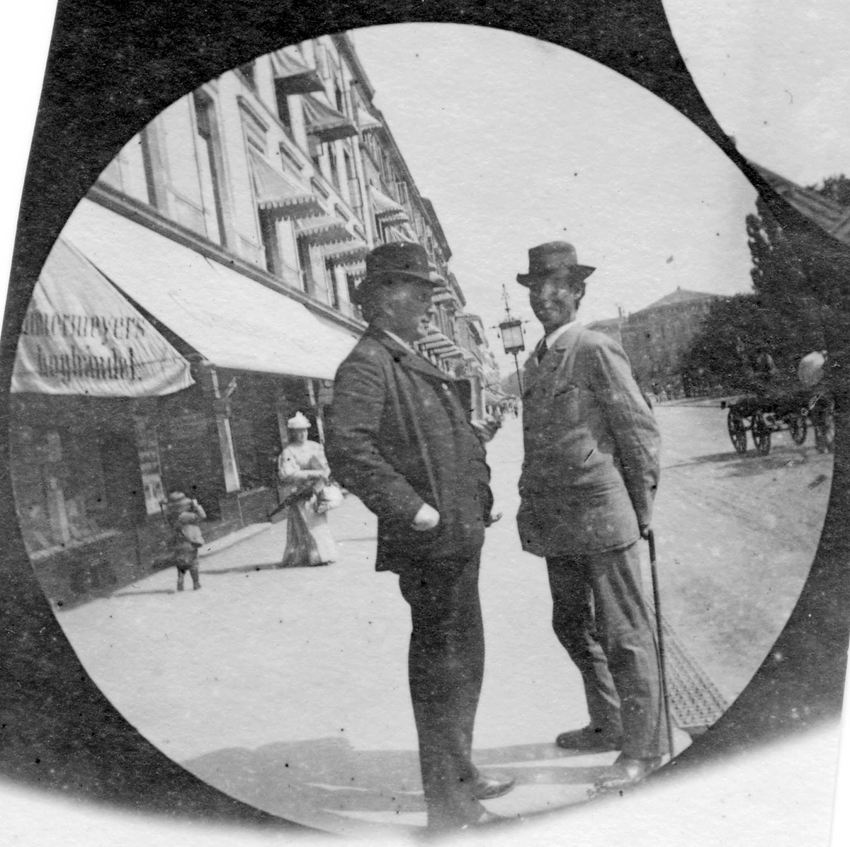 Fredrik Carl Mülertz Størmer, Nordahl Rolfsen og professor G. O. Sars står og prater på fortau langs Karl Johans gate, Oslo. Stortinget i bakgrunnen.