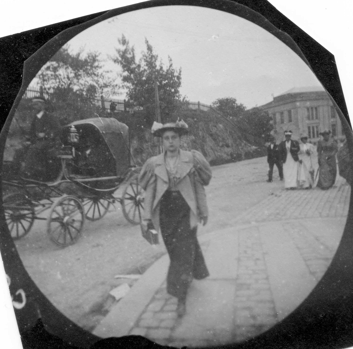 Fredrik Carl Mülertz Størmer, Frk. Robsham spaserer langs Drammensveien, Oslo. Slottsparken, hestevogn og Universitetet i bakgrunnen.