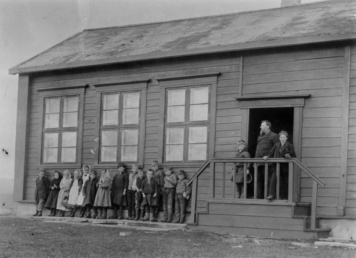 Ellisif Rannveig Wessel, Vestre Jakobselvs første skole, Vadsø, Finnmark. Lærer Thomas Lilleeng med sine elever foran skolen. Fotografert i 1890-årene.