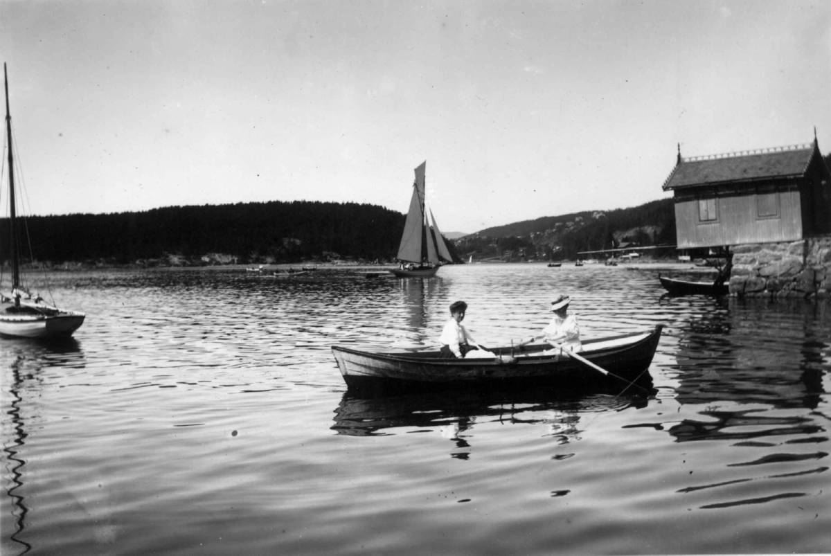 Hermann Christian Neupert, Ved Nordstrand, Bundefjorden. 1908-1910. Seilbåter. Kvinner i robåt. Brygger. Badehus.