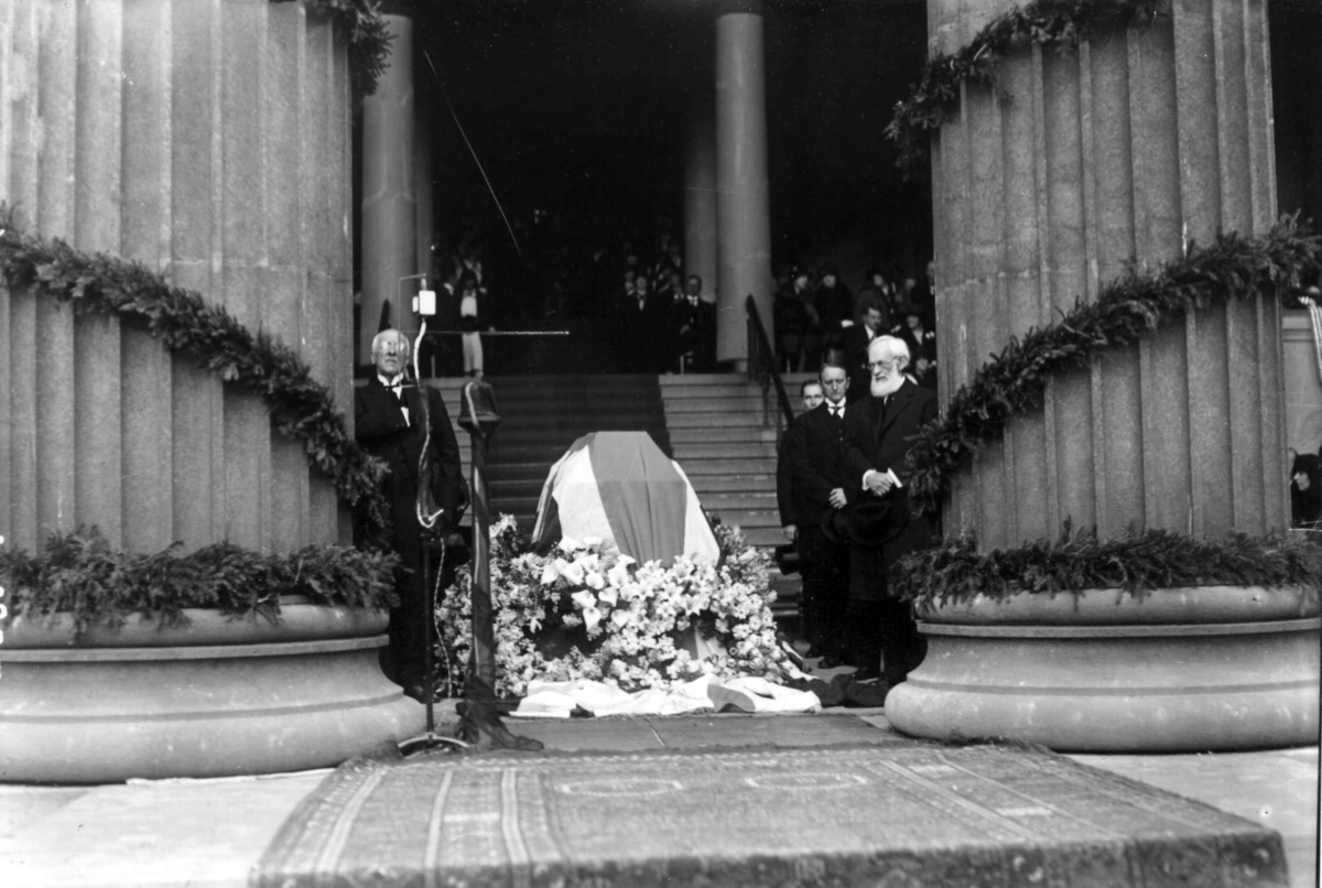 Hermann Christian Neupert, Fridtjof Nansen, hans begravelse 17. mai 1930. Kiste på lit de parade foran søylehallen i Universitetsbygget, Oslo. Kranser. Prest eller biskop. Æresgjester.