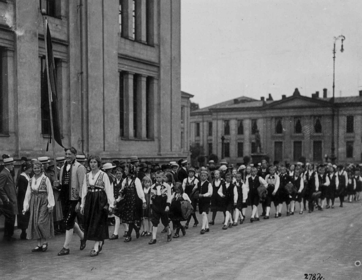 Hermann Christian Neupert, Oslo 17. mai-tog 1924. Passerer Universitetet på vei mot Slottet. Bunadkledte voksne og barn. Tilskuere.